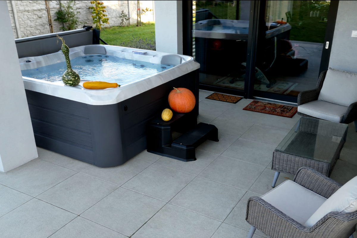 Jacuzzi ustawione na tarasie tuż przy domu zapewniające komfort korzystania zimą