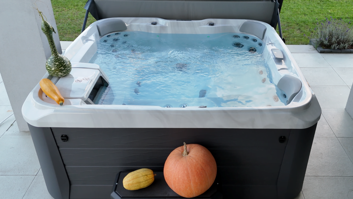 Nowoczesne jacuzzi przy domu na płytkowanym tarasie będącym przedłużeniem przestrzeni mieszkalnej