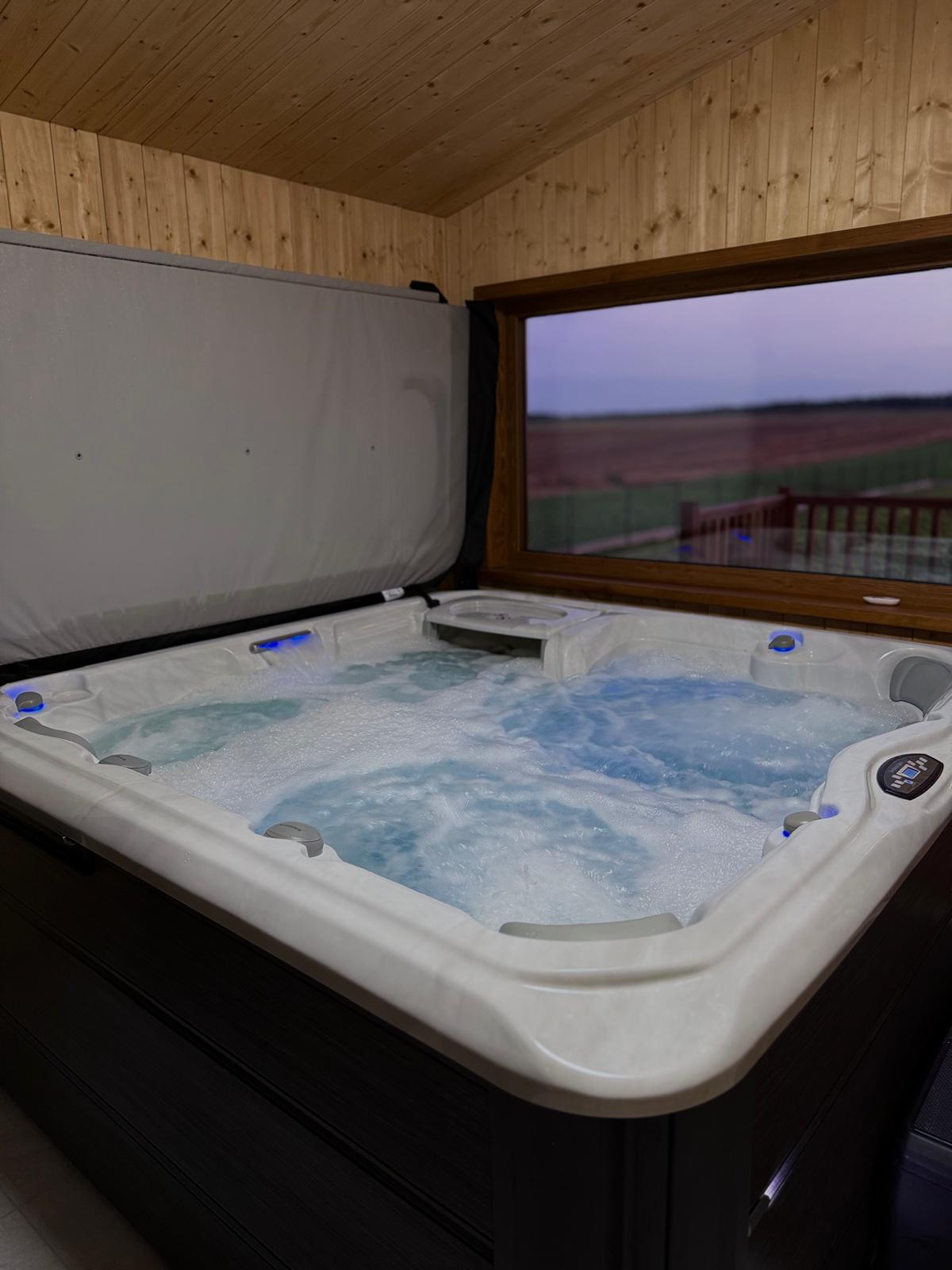 Jacuzzi w domku SPA z dużym oknem zapewniającym widok i komfort korzystania niezależnie od pogody